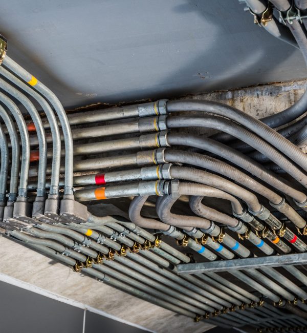 Odd angles of electrical conduits captured in black and white. Taken in an industrial building or architecture.
